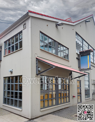 Corner of an office and production building on stormy sky background