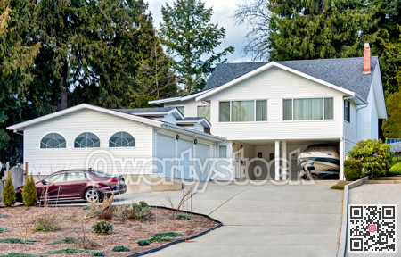 Suburban family house with small boat on trailer parked under carport