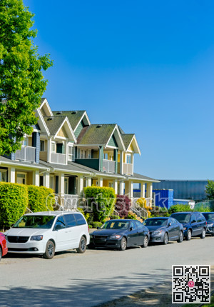 Street of townhomes with cars in front on summer season in British Columbia