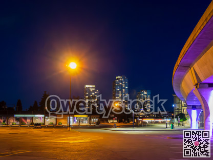 Night cityscape with skytrain rail and bright street light over the plaza
