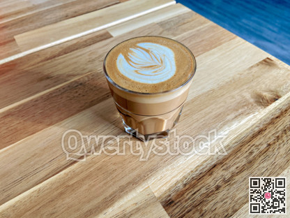 A glass of coffee latte on wooden texture of the table