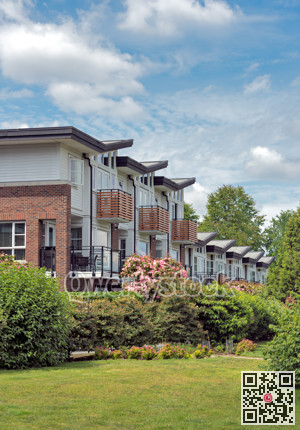 Row of residential townhouses on cloudy sky background