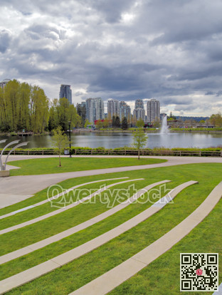 Landscaped recreation area with green lawn at Lafarge lake on cloudy day
