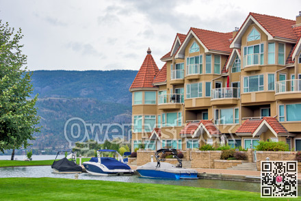 Luxury residential building with water channel and green lawn in front