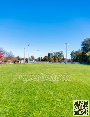 Empty football field with the gate in the end on blue sky background