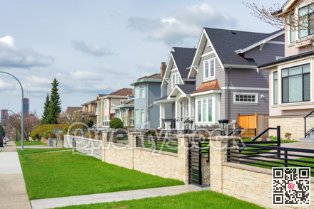 Street of luxury residential houses on cloudy day in Vancouver, Canada.