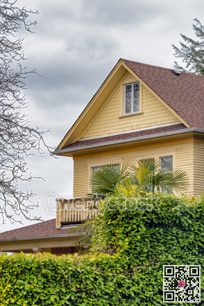 Top of yellow residential house on overcast sky background