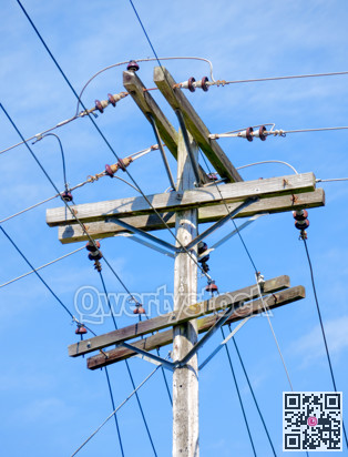 Electric pole and wires, wood electricty pole on blue sky background.