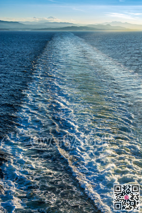 Foamy trail on water surface behind a big ocean vessel