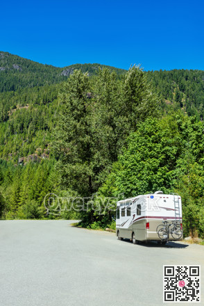 Luxury motorhome with bykes attached to the rack on an asphalt road