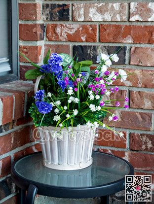 Decorative flowers in small basket on glass table