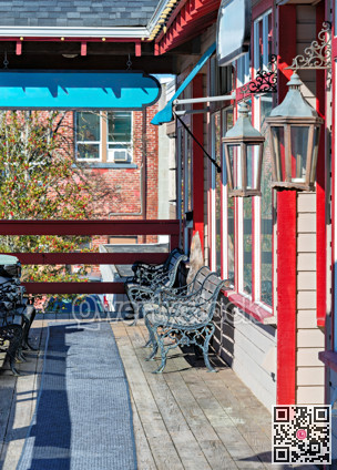 Wooden deck with benches in front of a street shop entrance