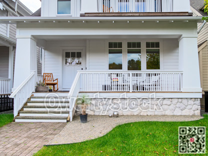 Entrance of detached residential house with rocking chair on front patio