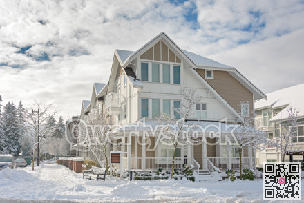Street of residential townhouses on bright winter day and cloudy sky background