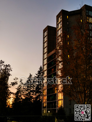 Sunset in a city. High-rise residential building on sunset sky background