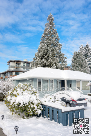 Residential house in snow with a car parked on driveway
