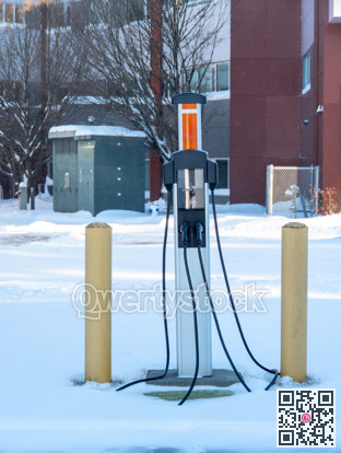 EV charging station on winter season with power trasformator on the back