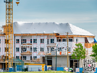 New low-rise residential building under construction on blue sky background