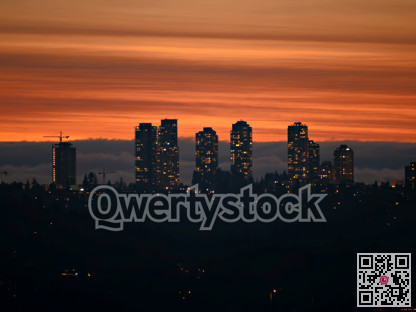 City lights after sunset on darker sky and cumulus clouds background