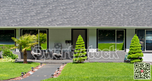 Main entrance of residential house with concrete pathway on bright sunny day