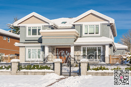 Luxury residential house with front yard in snow on winter sunny day