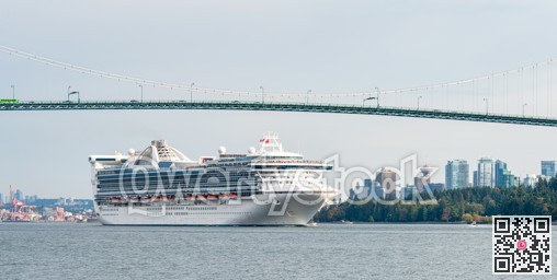 Huge white ocean cruise liner passing famous Lion Gates Bridge