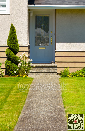 Family house entrance with doorsteps and concrete pathway over the front yard