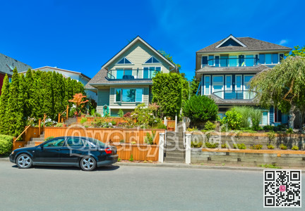 Suburban family houses with landscaped terraces and car parked in front