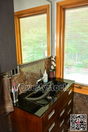 Black wash-basin at the window in a bathroom of luxury house.