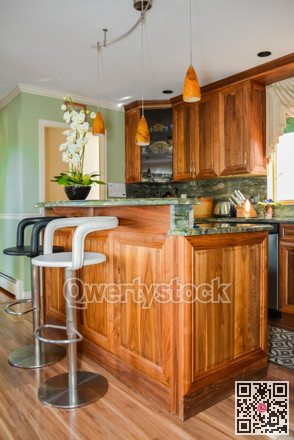 Stylish kitchen wooden interior with high chairs beside the island table.
