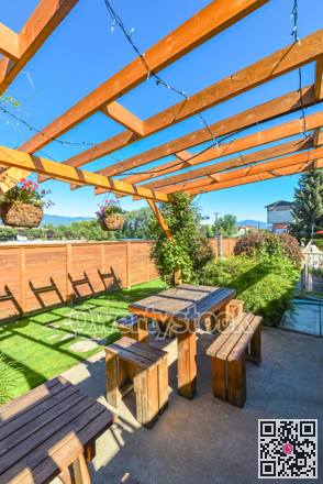 Barbecue and picnic area of hotel with row of tables and grills under the shed.