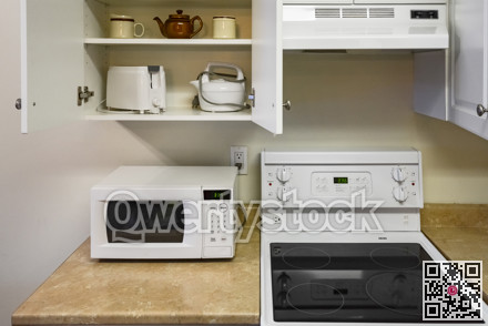 Open cabinets and primary appliances on average home kitchen.