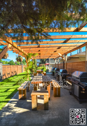Barbecue and picnic area of hotel with row of tables and grills under the shed.