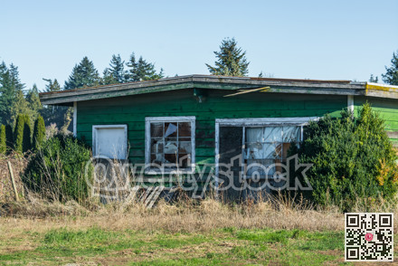 Old abandoned house in disrepair on cold fall day.