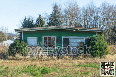 Old abandoned house in disrepair on cold fall day.