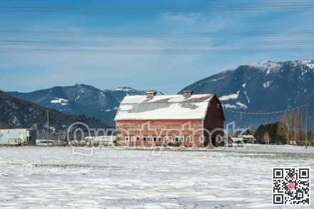 Industrial agriculture building in disrepair. Old red barn with mountain view