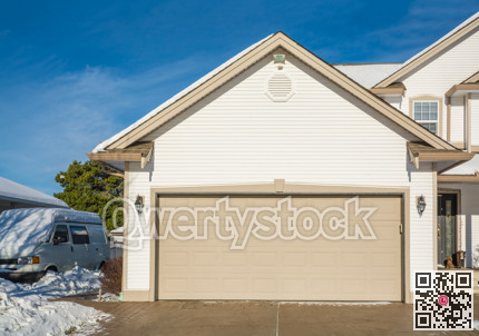 Wide garage door of luxury house with RV wagon parked nearby