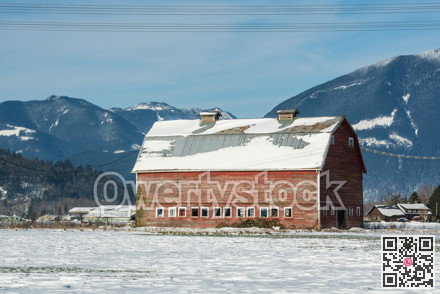 Industrial agriculture building in disrepair. Old red barn with mountain view