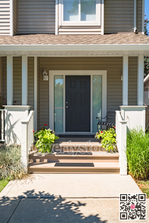 Family house main entrance under the porch decorated with blossoming flowers