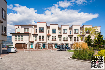 Townhomes with wide garage door and cars parked in front
