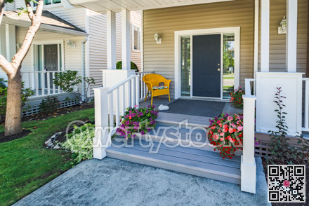 Door steps and concrete pathway to residential house entrance under the porch