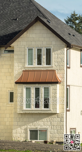 Facade of residential house with unpaved driveway in front