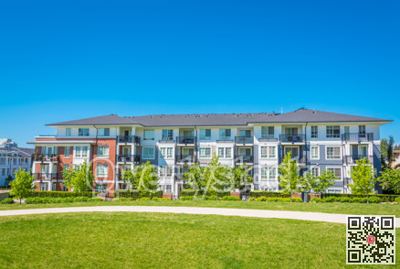 Concrete pathway across huge green lawn in front of residential condo building