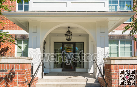 Main entrance of brand new apartment building on sunny day.