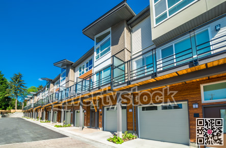 Row of brand new townhouses on sunny day.