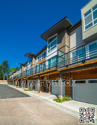 Row of brand new townhouses on sunny day.