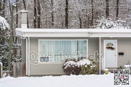 Entrance of residential house with front yard in snow on winter day