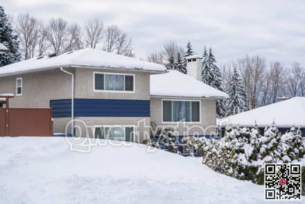 Family residential house with front yard in snow on winter cloudy day