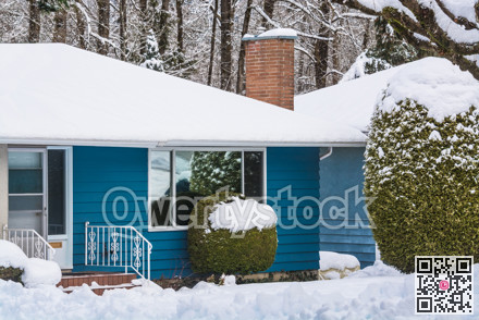 Entrance of residential house with front yard in snow on winter cloudy day