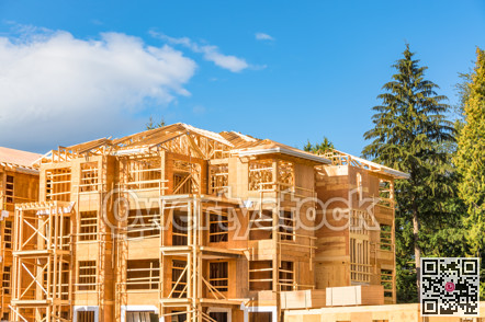 Apartment building under construction with two timber trunks on side